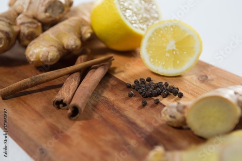 Close-up of lemon and various spices on wooden serving board