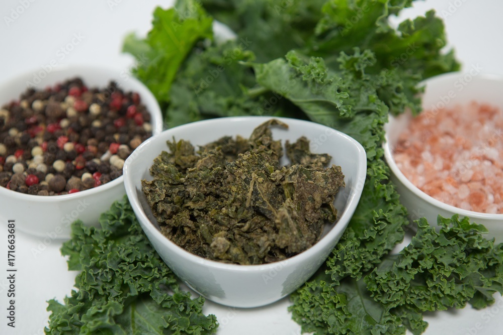 Close up of peppercorn and salt with kale Close up of peppercorn and salt with kale