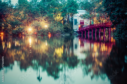 hanoi Red Bridge at night. The wooden red-painted bridge over the Hoan Kiem Lake connects the shore and the Jade Island on which Ngoc Son Temple stands. photo