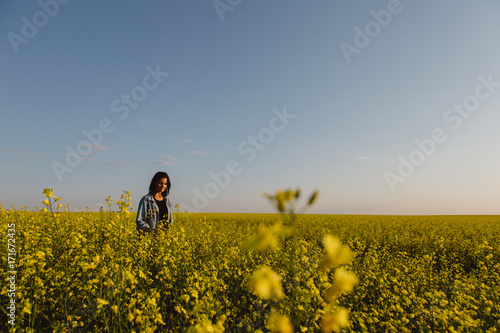 Female farmer standing in field of canola