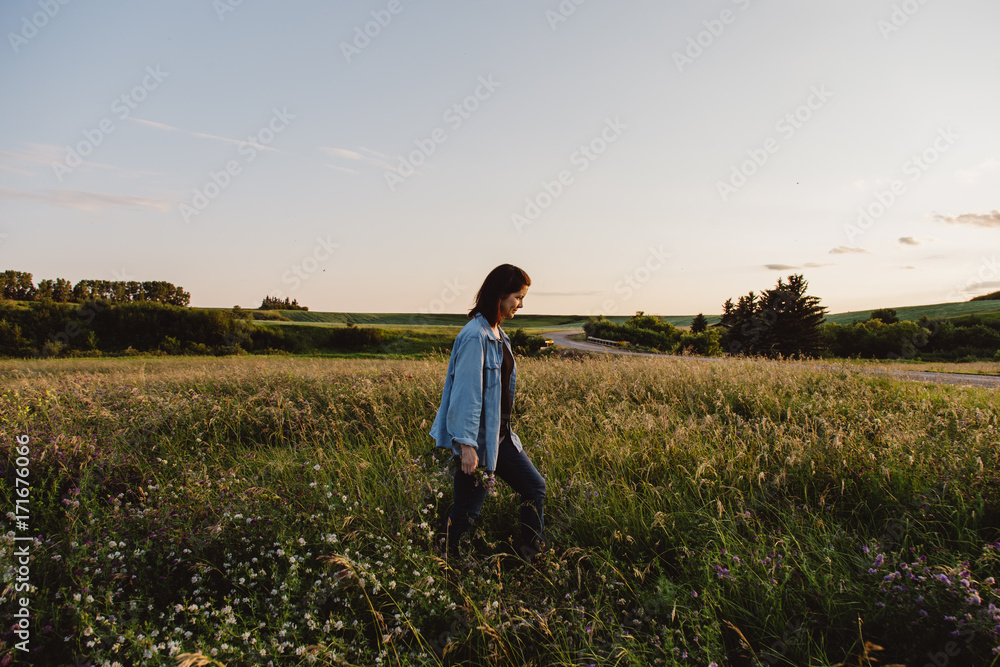 Woman walking through field of tall grass Woman walking through field of tall grass