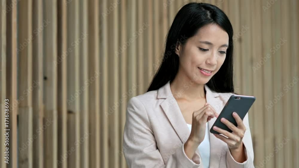Business woman working on cellphone in corporate building Business woman working on cellphone in corporate building