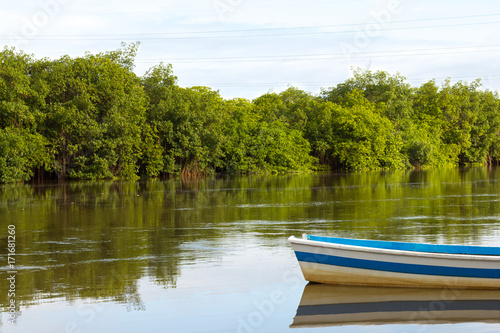 Boat reflection in calm river water.