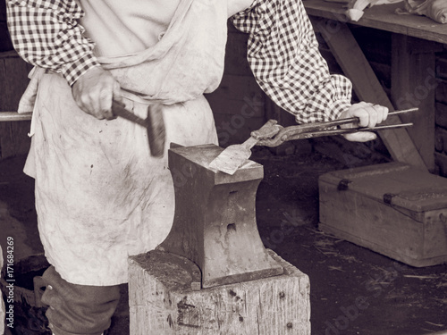 Blacksmith at work with tools forging iron