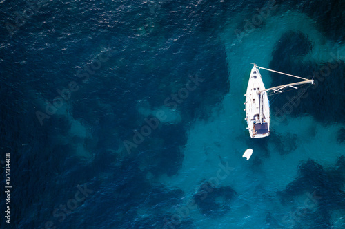 Aerial view of anchored sailing yacht in emerald sea