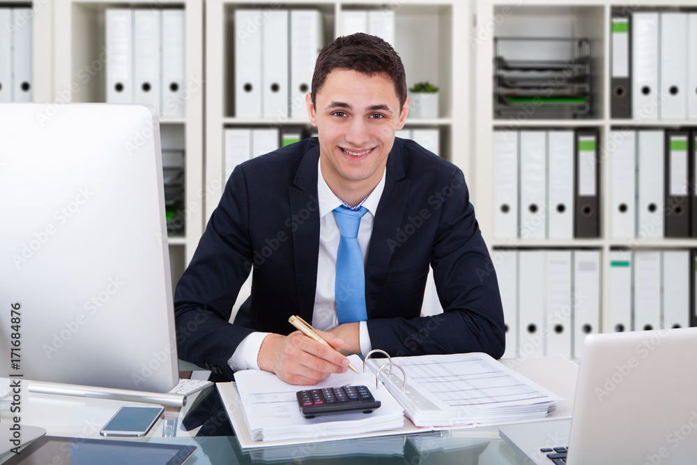 Smiling Businessman Calculating Tax Smiling Businessman Calculating Tax