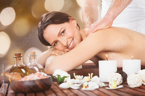 Woman Receiving Back Massaging In Spa