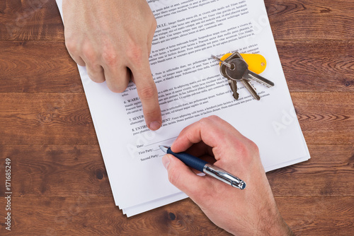 Fotografie Real Estate Agent Helping Client In Filling Contract Form