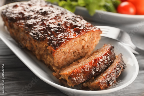 Plate with tasty baked turkey meatloaf on table, closeup