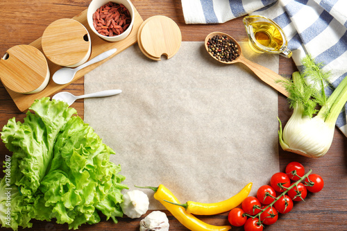 Parchment paper with vegetables and spices on kitchen table. Cooking classes concept