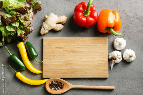 Wooden board and vegetables on kitchen table. Cooking classes concept photo