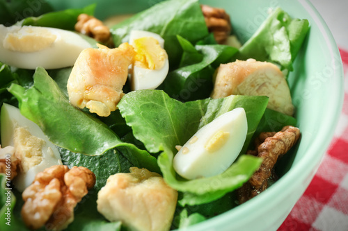 Salad with quail egg and spinach in bowl, close up