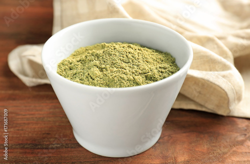 Hemp protein powder in bowl on wooden table