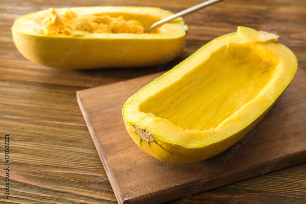 Half of fresh spaghetti squash without seeds on wooden board