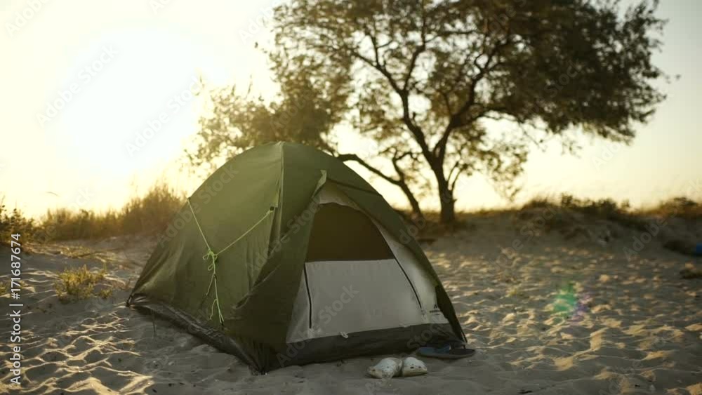 Tent camp during sunset or sunrise on the beach of the island Tent camp during sunset or sunrise on the beach of the island