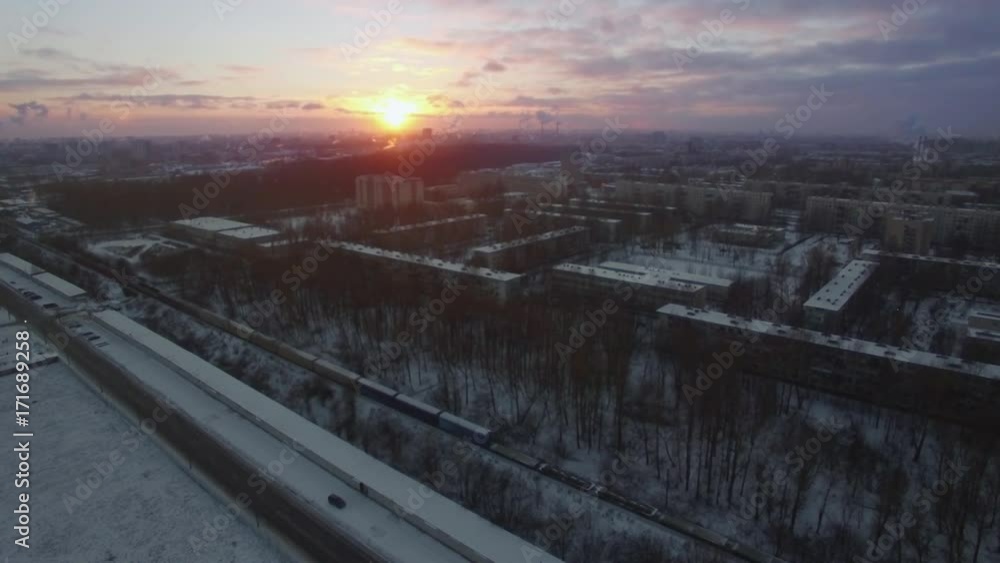 Aerial shot of snowy Saint Petersburg at dawn, Russia. Winter scene with typical apartment blocks, roads and cargo train moving across the city Aerial shot of snowy Saint Petersburg at dawn, Russia. Winter scene with typical apartment blocks, roads and cargo train moving across the city