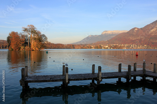 An island covered in trees on Lake Annecy in autumn, France.
