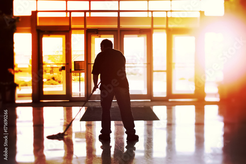 Janitor mopping an office floor, shallow focus, tilt shift image photo