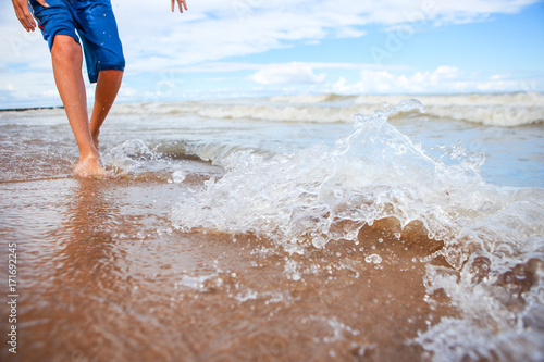 Blurred image of a child on the beach and splash of waves