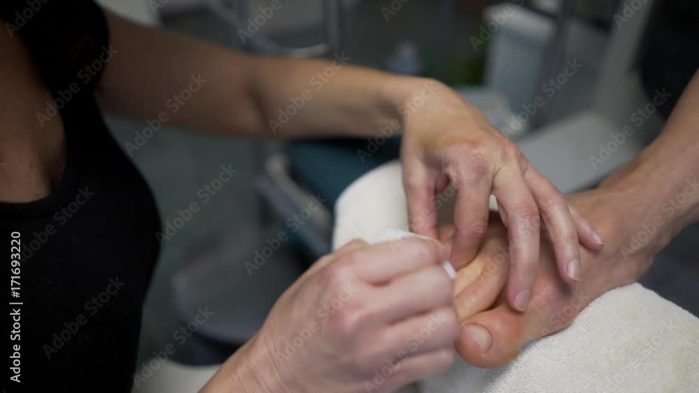 Woman gets her toenails buffed. Steadicam shot. Woman gets her toenails buffed. Steadicam shot.