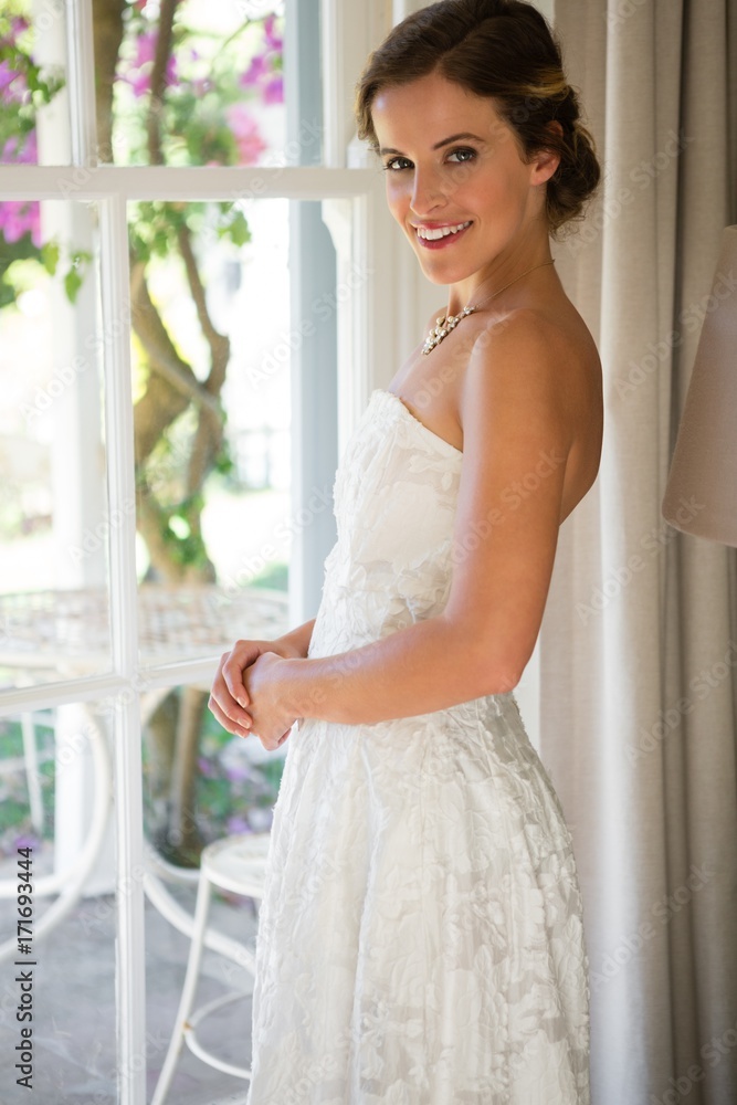 Portrait of beautiful bride standing by window Portrait of beautiful bride standing by window