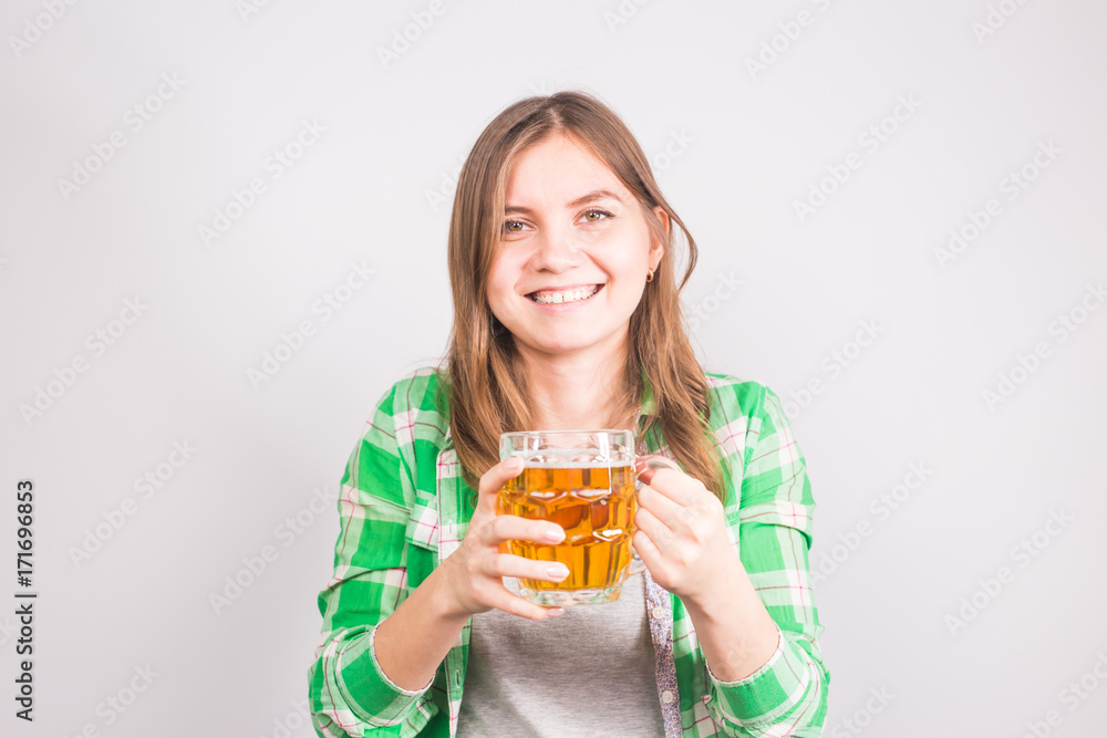 Cheerful young woman holding a beer mug full of beer and smiling on white background Cheerful young woman holding a beer mug full of beer and smiling on white background