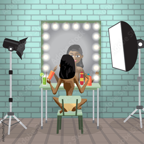 Young afro woman in photo studio in front of a mirror make make-