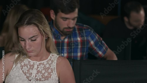 Group of friends watching a movie at the cinema theater and applauding at the end photo