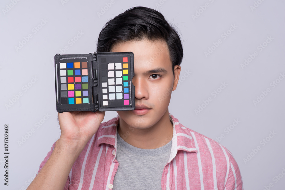 Young asian photographer holding digital camera, while working in studio Young asian photographer holding digital camera, while working in studio
