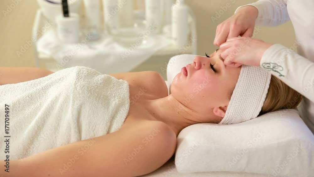 Doctor cosmetologist doing facial massage for girl Doctor cosmetologist doing facial massage for girl