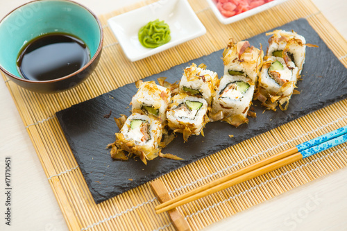 Sushi rolls on black slate surface. Japanese food. Set of sushi and maki on stone table