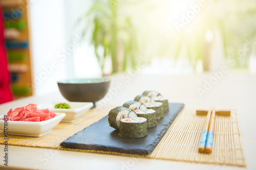 Sushi rolls on black slate surface. Japanese food. Set of sushi and maki on stone table