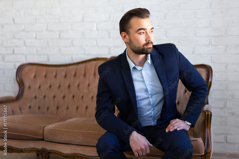 richness, success and fashion concept - handsome man in business suit sitting on vintage sofa richness, success and fashion concept - handsome man in business suit sitting on vintage sofa