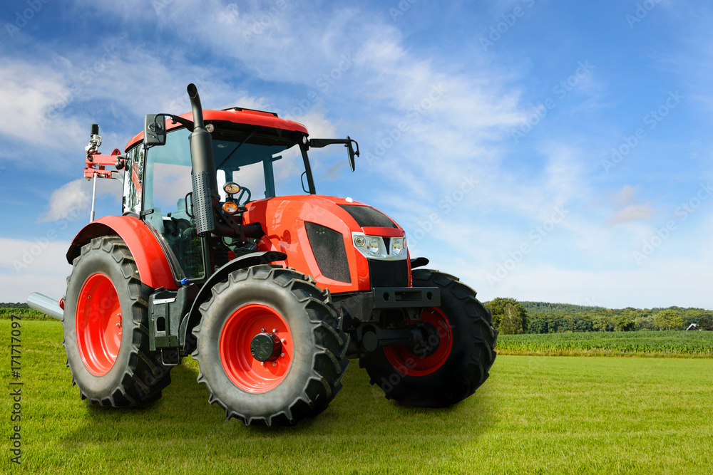 Composite image of a modern red agricultural generic tractor on a green field on a sunny day. Composite image of a modern red agricultural generic tractor on a green field on a sunny day.