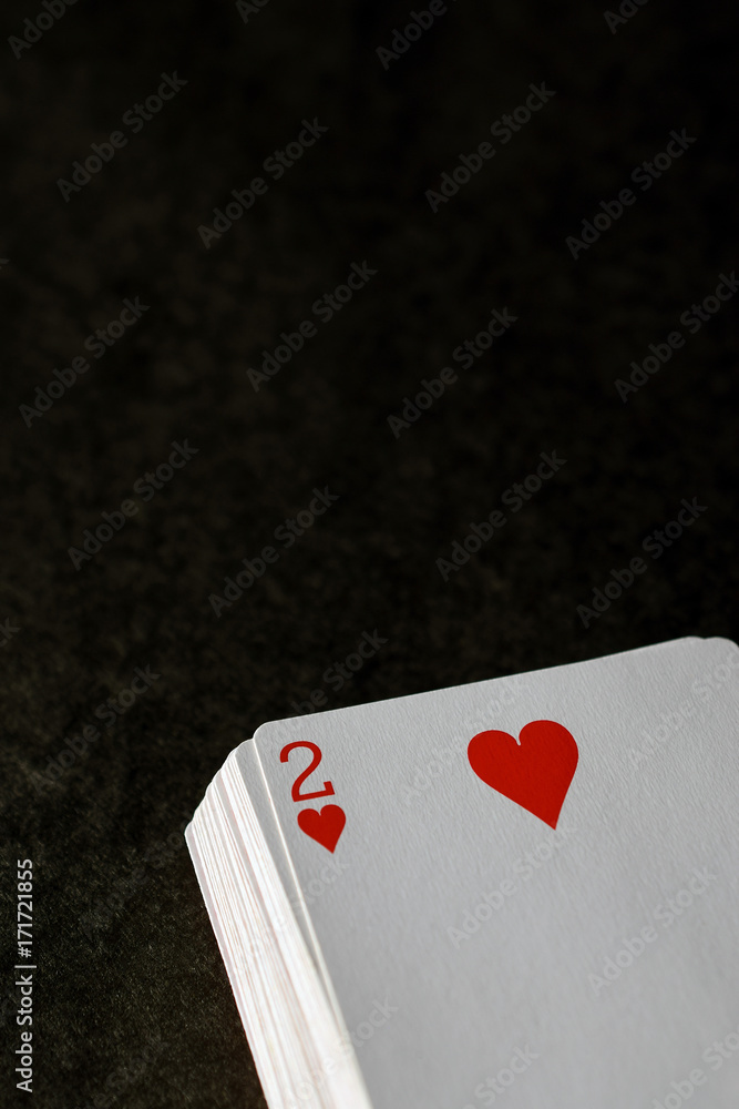 Stack of playing cards, two of hearts on top