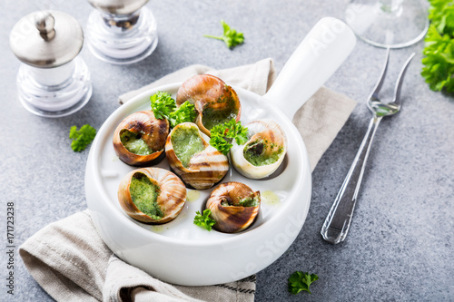 Bourgogne Escargot Snails with garlic herbs butter in white pan on light gray background. Healthy food concept. photo