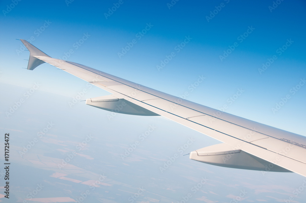 Obraz premium The wing of an airplane in the sky above the clouds.