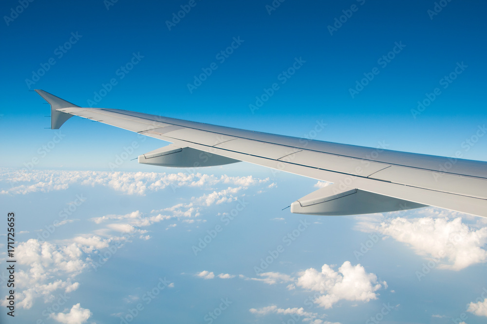 Fototapeta premium The wing of an airplane in the sky above the clouds.