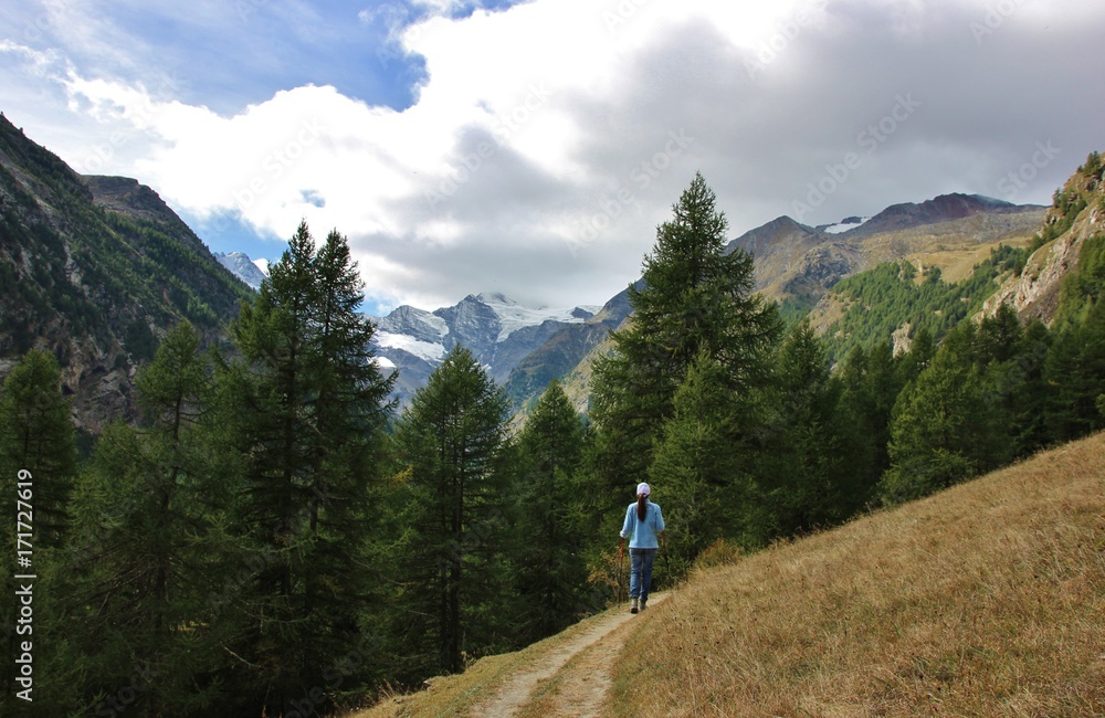 Female hiker hiking on Valnontey way path towards Grand Paradiso peak, Gran Paradiso national park, Italy