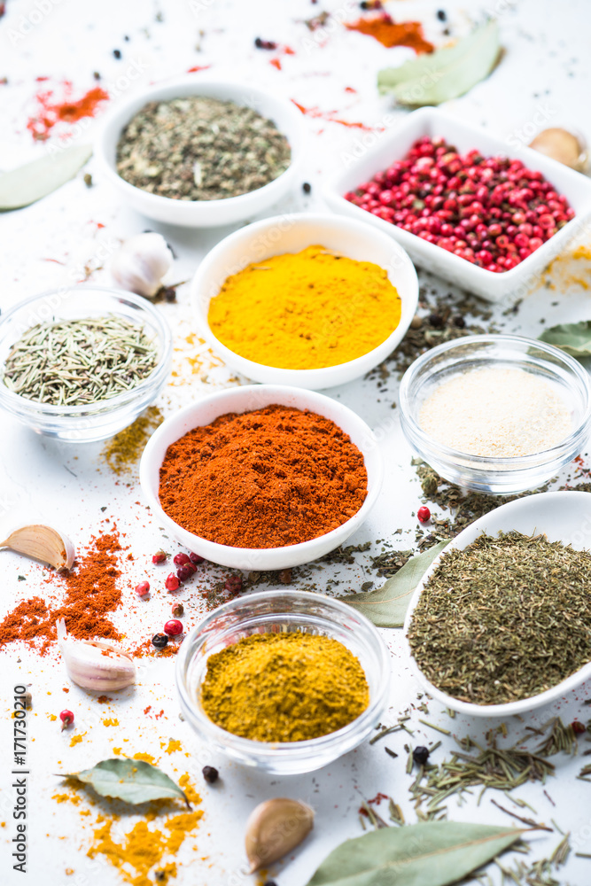 Various spices in a bowls on white.