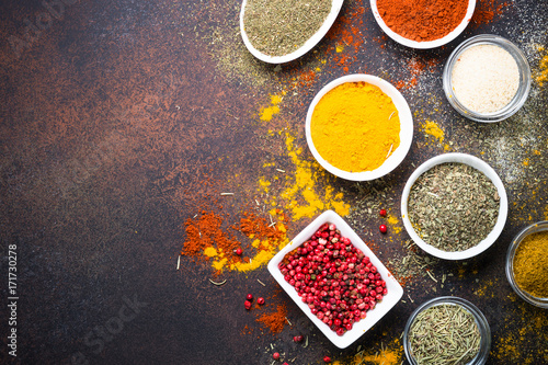 Various spices in a bowls on stone table. Top view. © nadianb