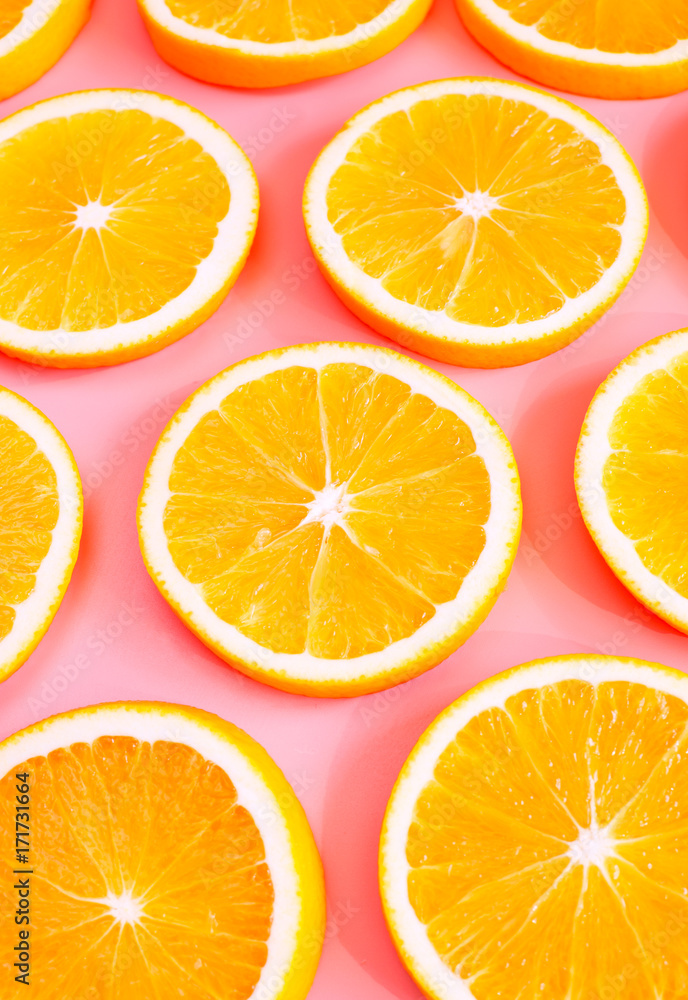 Fototapeta premium Fresh cut oranges on pink background. Selective focus.