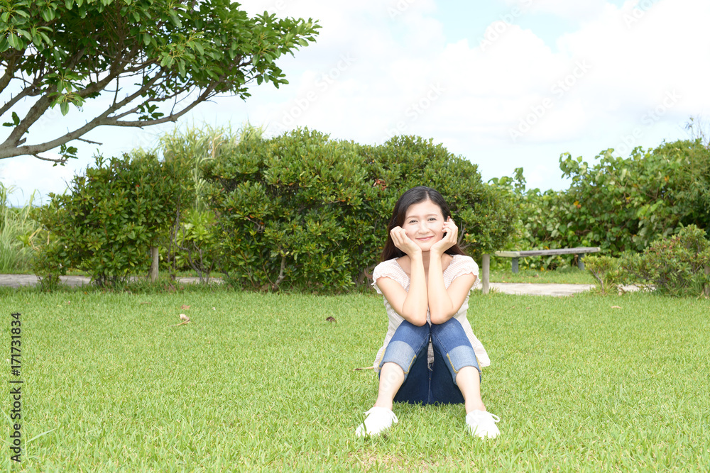 芝生の上でくつろぐ女性