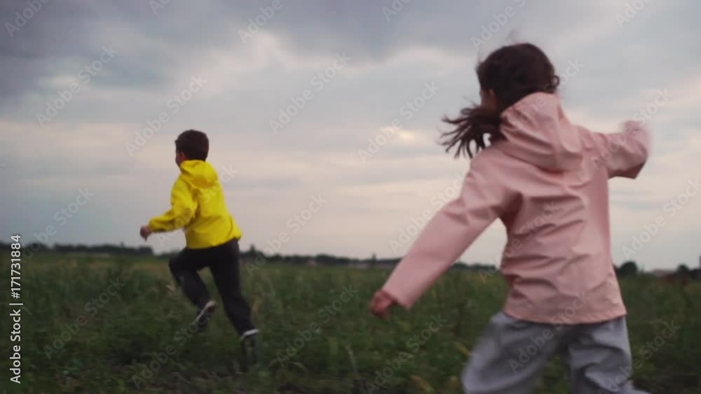 two kids boy and girl enjoying running on nature having fun in cold season slow motion two kids boy and girl enjoying running on nature having fun in cold season slow motion