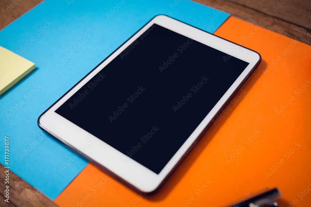 High angle view of digital tablet on papers High angle view of digital tablet on papers