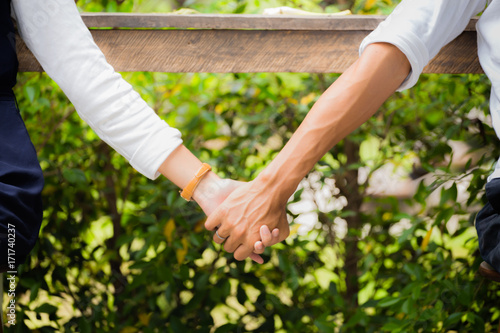 Couple holding hands in the park, together