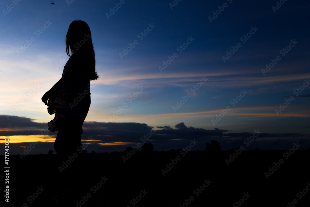Silhouette of woman posing at sunset or sunrise Silhouette of woman posing at sunset or sunrise
