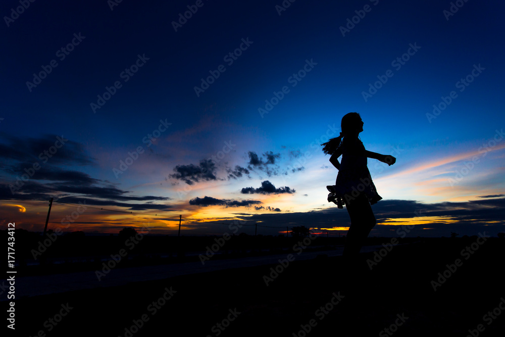 Silhouette of woman posing at sunset or sunrise