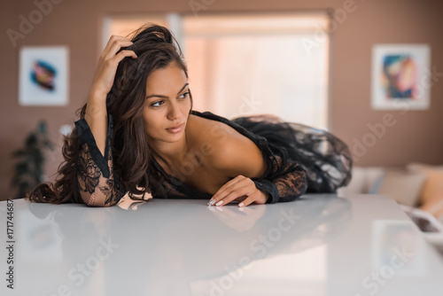 Canvastavla beautiful and sexy girl lying on the table in the luxurious apartment