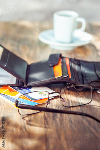 Leather men's open wallet with credit cards  eyeglasses and coffee cup